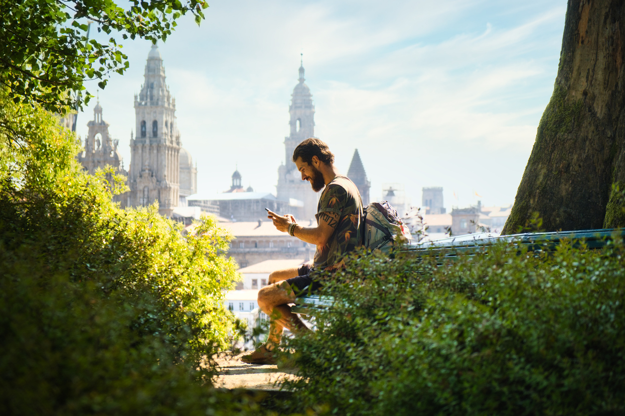 Mochilero descansando con la catedral de Santiago de Compostela al fondo